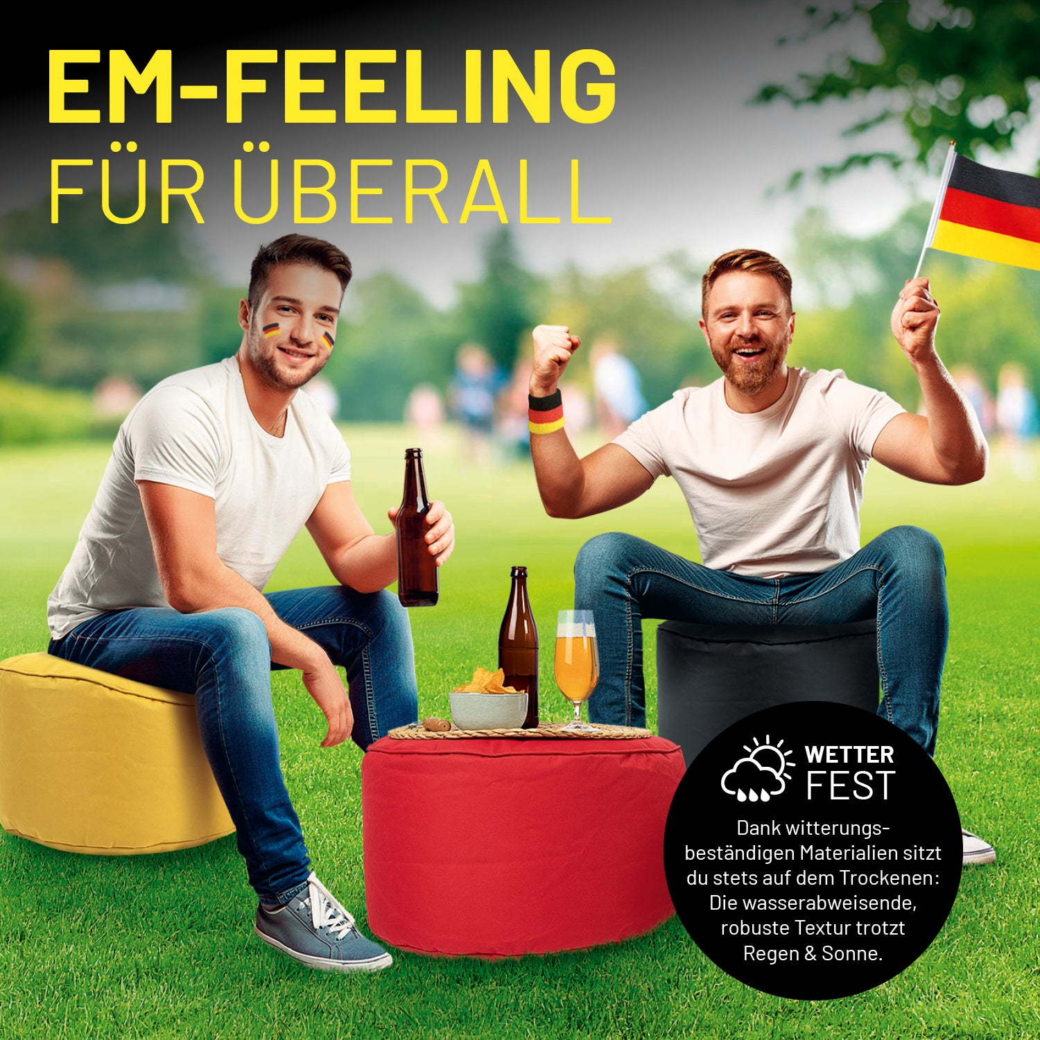 Zwei Deutschland-Fans sitzen in einem Park auf den Poufs und nutzen den dritten Pouf als Ablage für Getränke und Snacks.