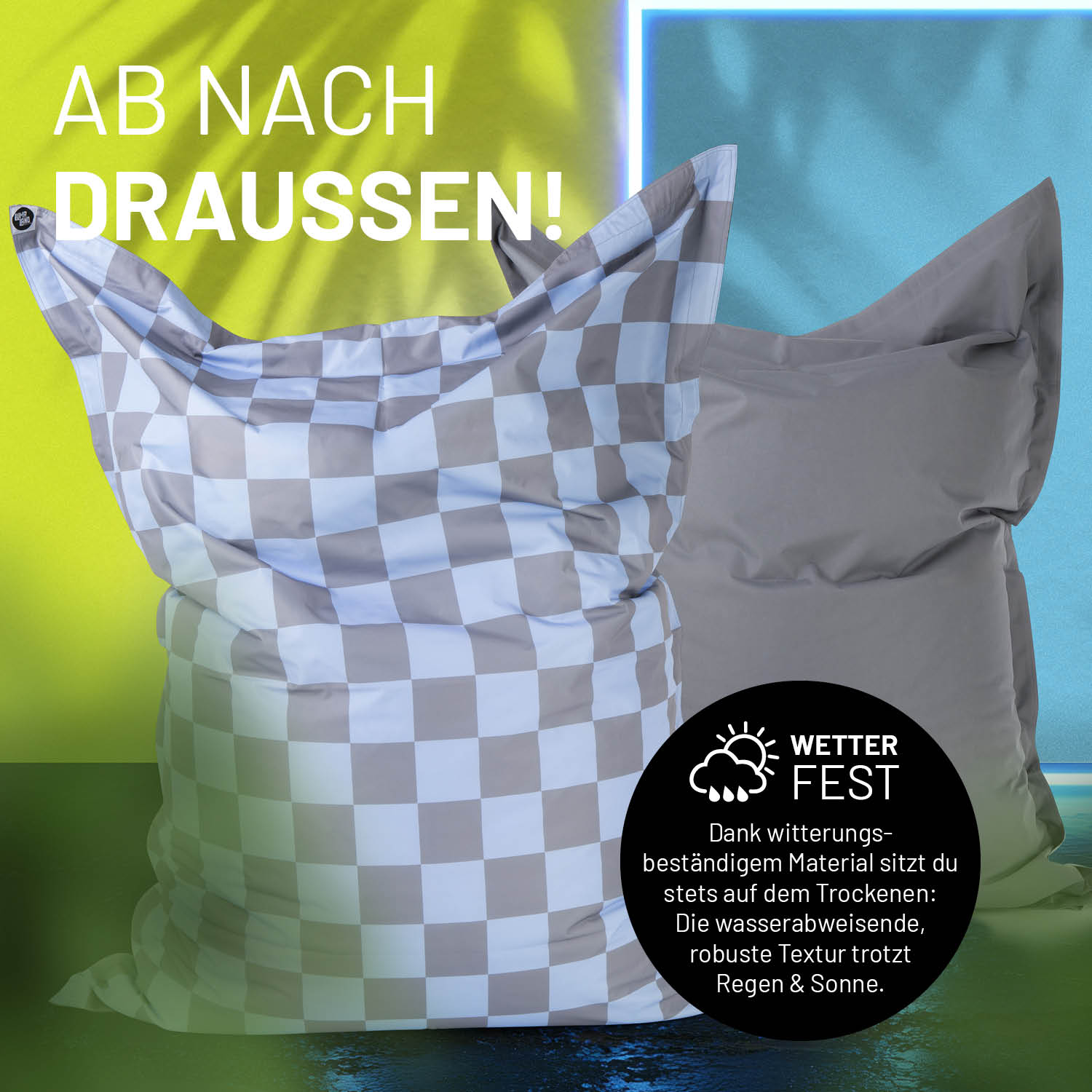 Der XXL Sitzsack mit karierter Vorder- und unifarbener grauer Rückseite in einer Outdoorszene mit Hinweis zur Wetterfestigkeit.