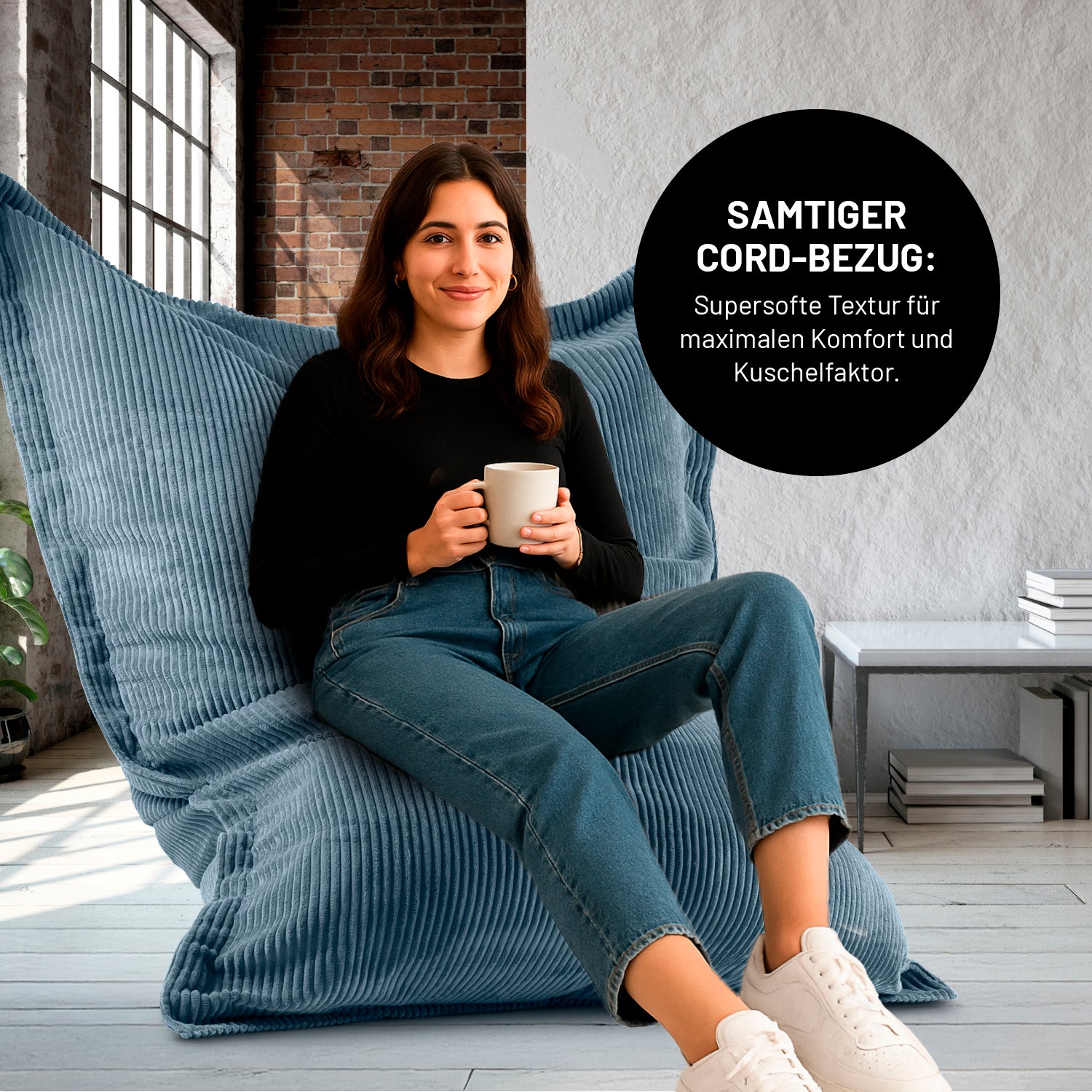 Eine Frau mit Kaffeetasse sitzt in einem Wohnzimmer auf dem XXL-Sitzsack mit Cord Bezug, Icon "Samtiger Cord-Bezug für maximalen Komfort und Kuschelfaktor".
