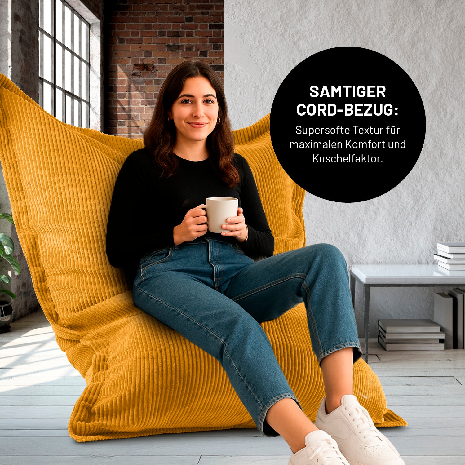 Eine Frau mit Kaffeetasse sitzt in einem Wohnzimmer auf dem XXL-Sitzsack mit Cord Bezug, Icon "Samtiger Cord-Bezug für maximalen Komfort und Kuschelfaktor".