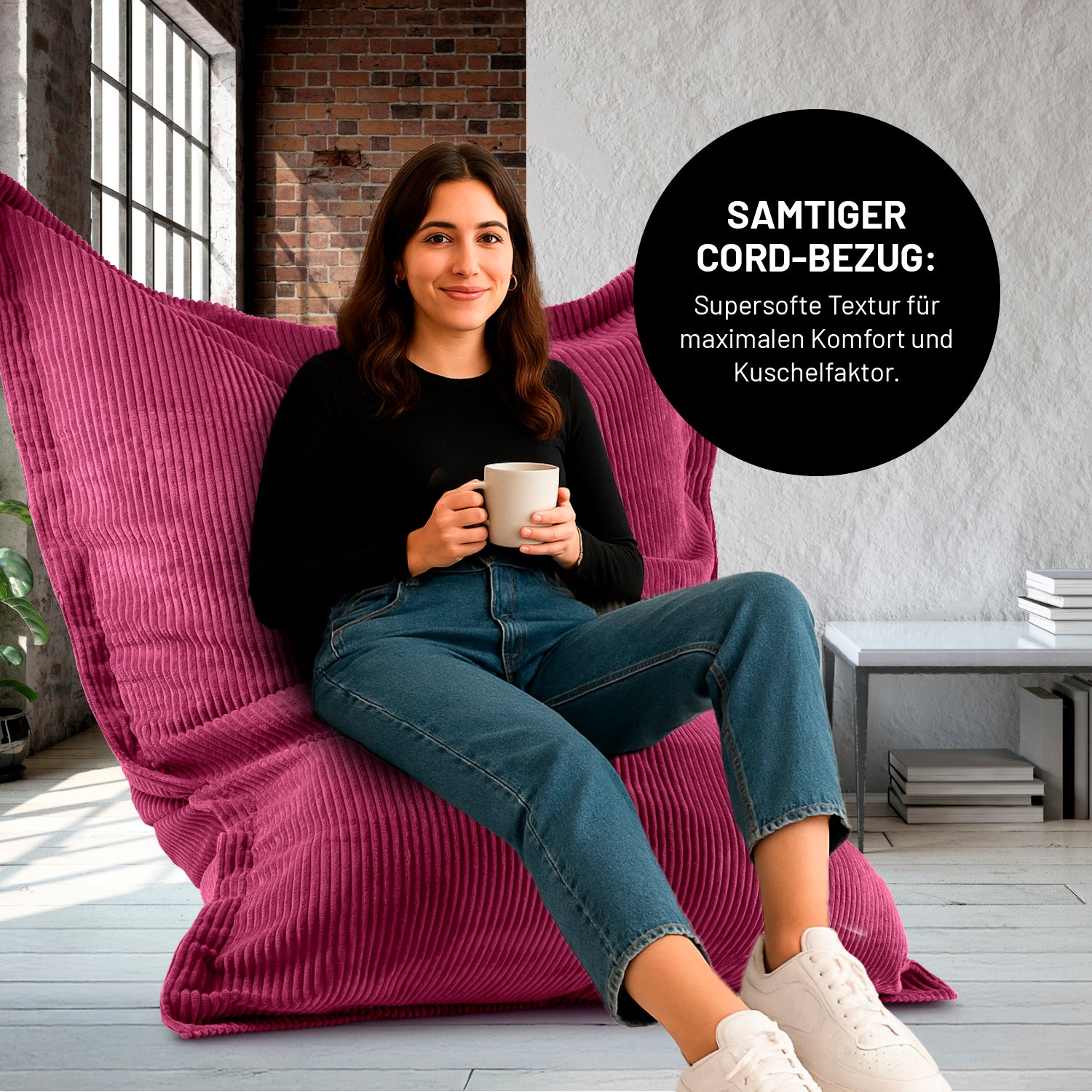 Eine Frau mit Kaffeetasse sitzt in einem Wohnzimmer auf dem XXL-Sitzsack mit Cord Bezug, Icon "Samtiger Cord-Bezug für maximalen Komfort und Kuschelfaktor".