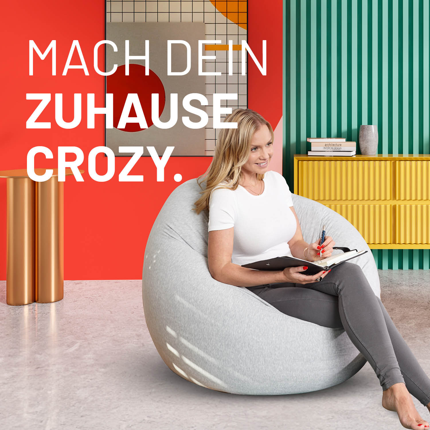 Eine Frau mit Notizblock sitzt im flexiblen Sitzsack in einem modernen bunten Wohnzimmer - Mache dein Zuhause Crozy.