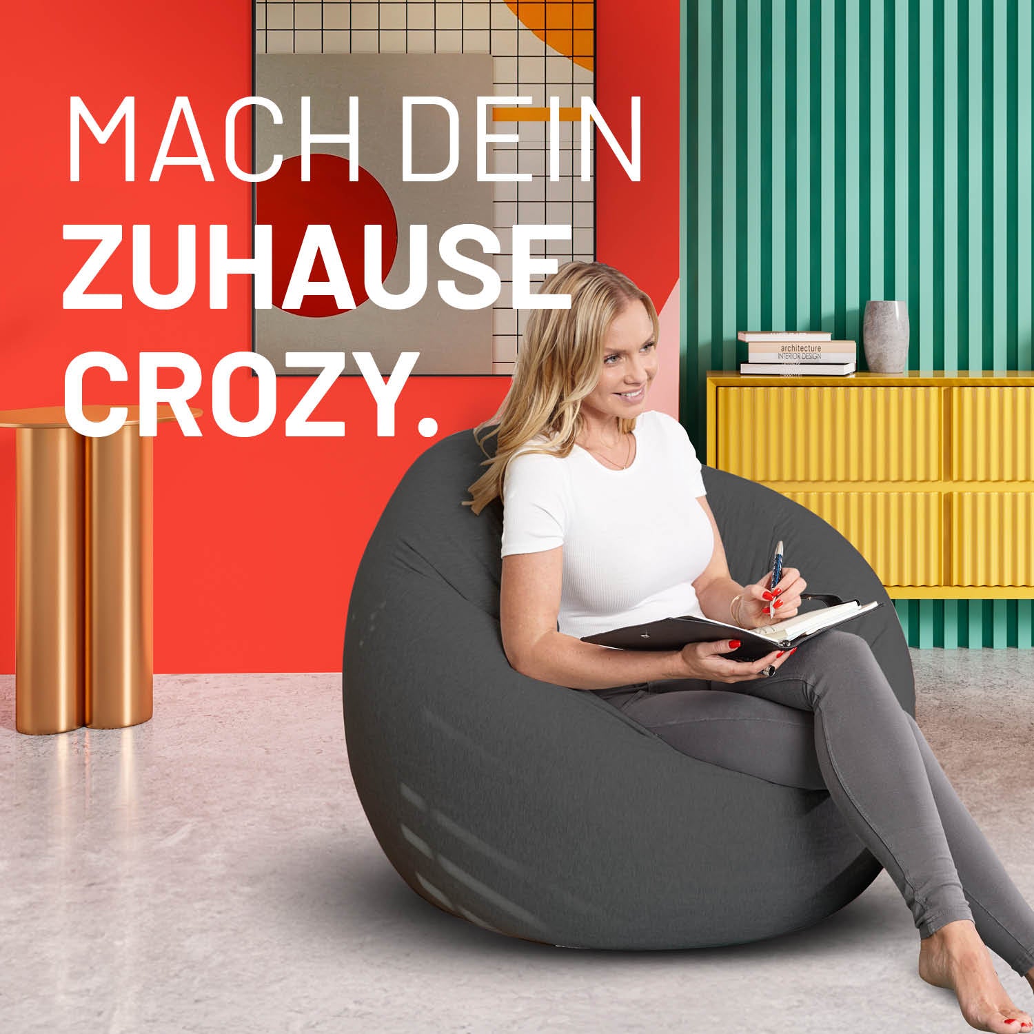 Eine Frau mit Notizblock sitzt im flexiblen Sitzsack in einem modernen bunten Wohnzimmer - Mache dein Zuhause Crozy.