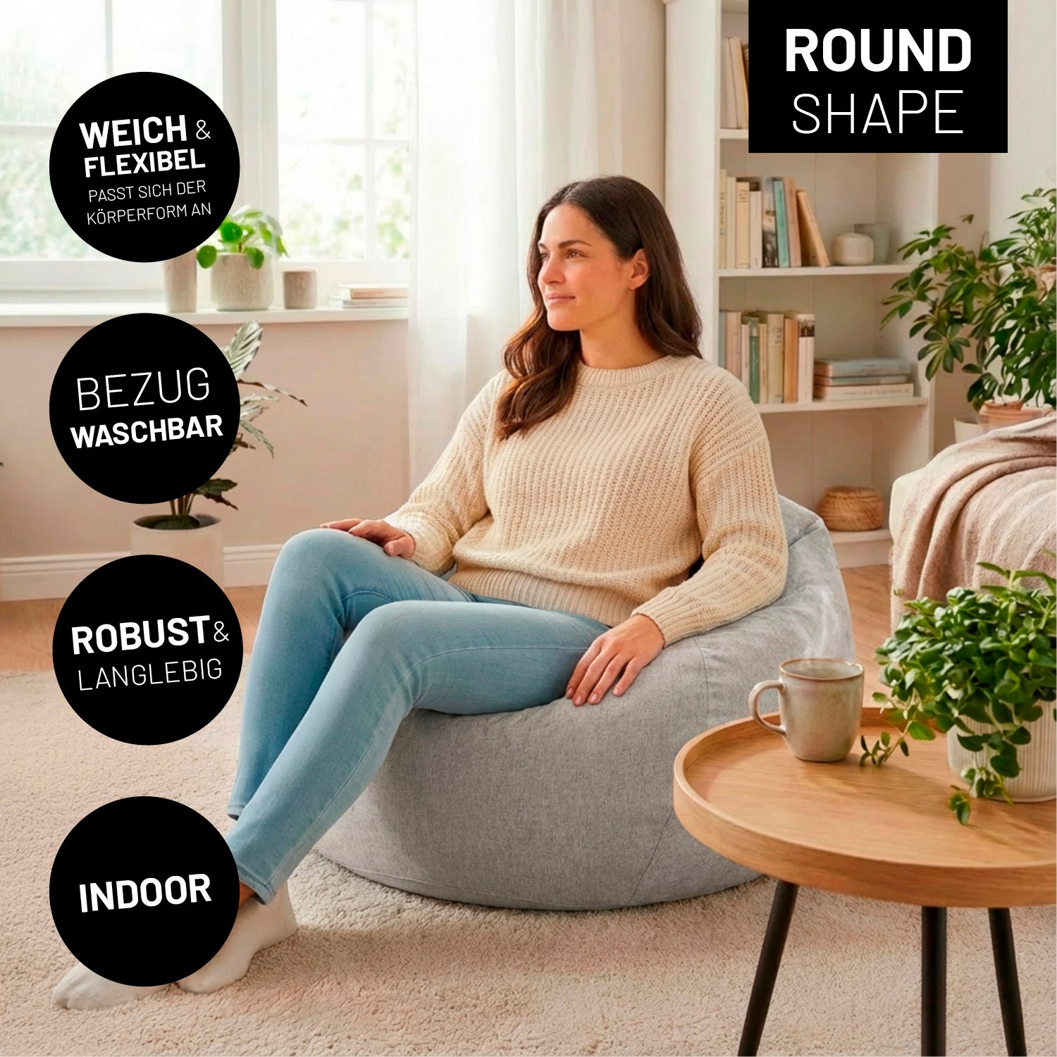 Eine Frau sitzt entspannt auf dem rundem Indoor-Sitzsack aus der Comfort Line im Wohnzimmer. Icons zu "weich & flexibel", "Bezug waschbar", "Robust & Langlebig" und "Indoor".