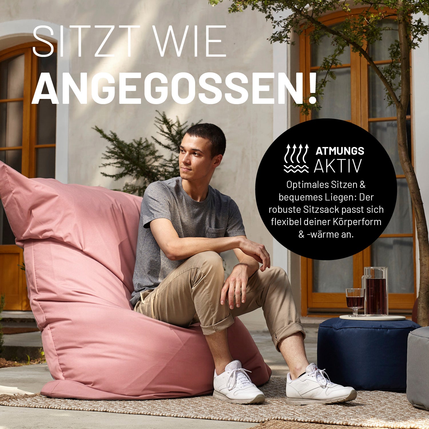 Ein Mann sitzt auf dem XXL Sitzsack auf einer Terrasse. Icon "Atmungsaktiv" und "Passt sich Körperform und -wärme an".