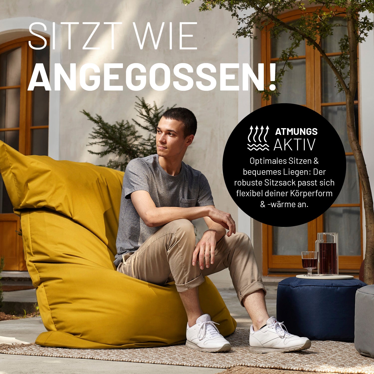 Ein Mann sitzt auf dem XXL Sitzsack auf einer Terrasse. Icon "Atmungsaktiv" und "Passt sich Körperform und -wärme an".