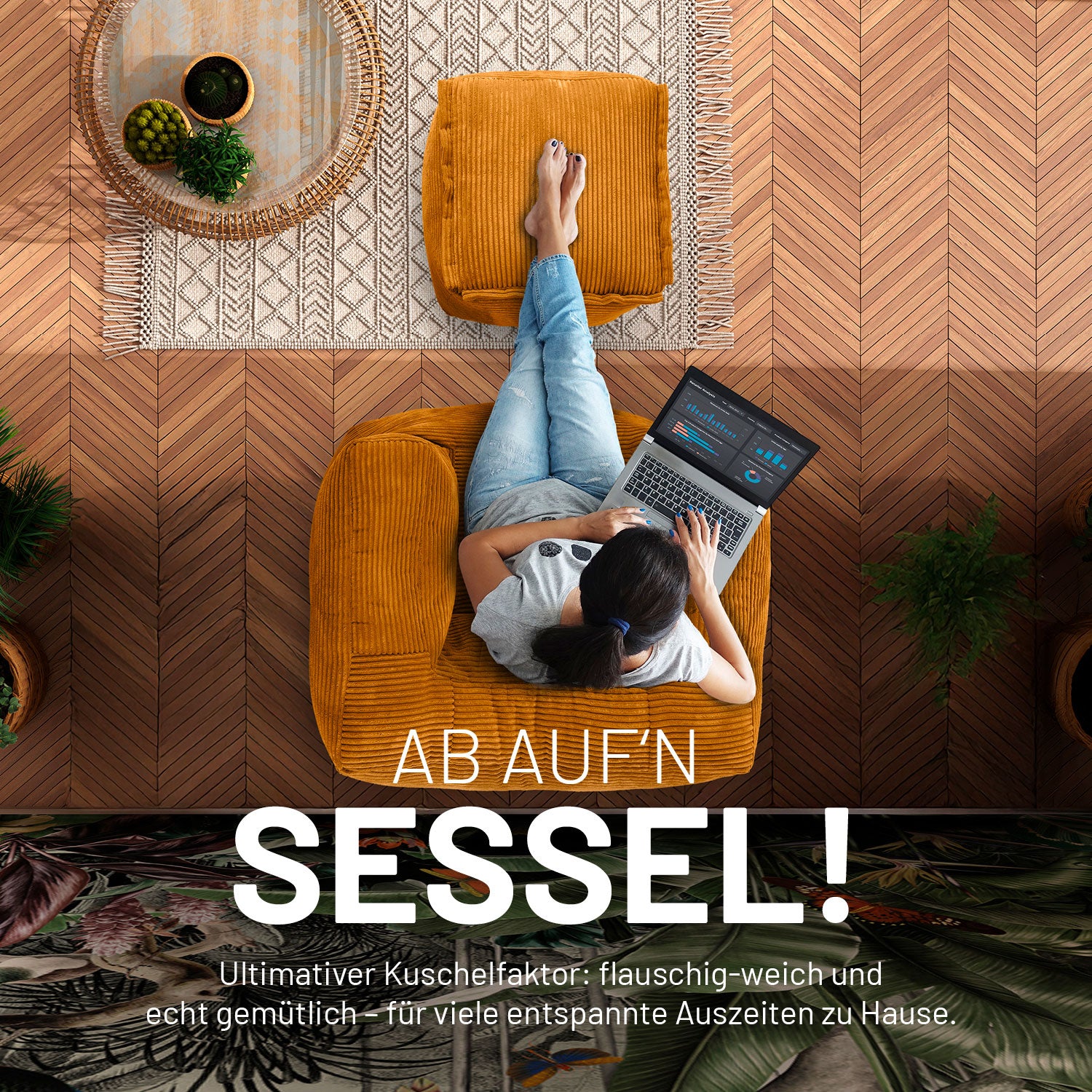 Frau mit Laptop sitzt auf dem senfgelben modularen Sitzsack-Sessel in Cord und hat die Füße auf dem passenden Cord-Pouf/Hocker.