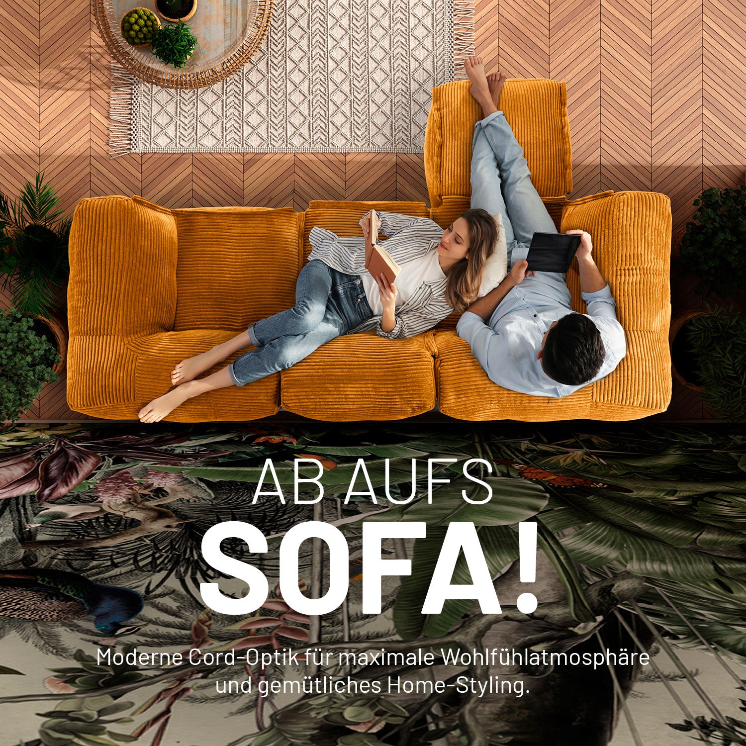 Frau mit Buch und Mann mit Tablet enspannen auf dem senfgelben Cord-Sitzsack-Sofa in einem modernen Wohnzimmer aus der Vogelperspektive.