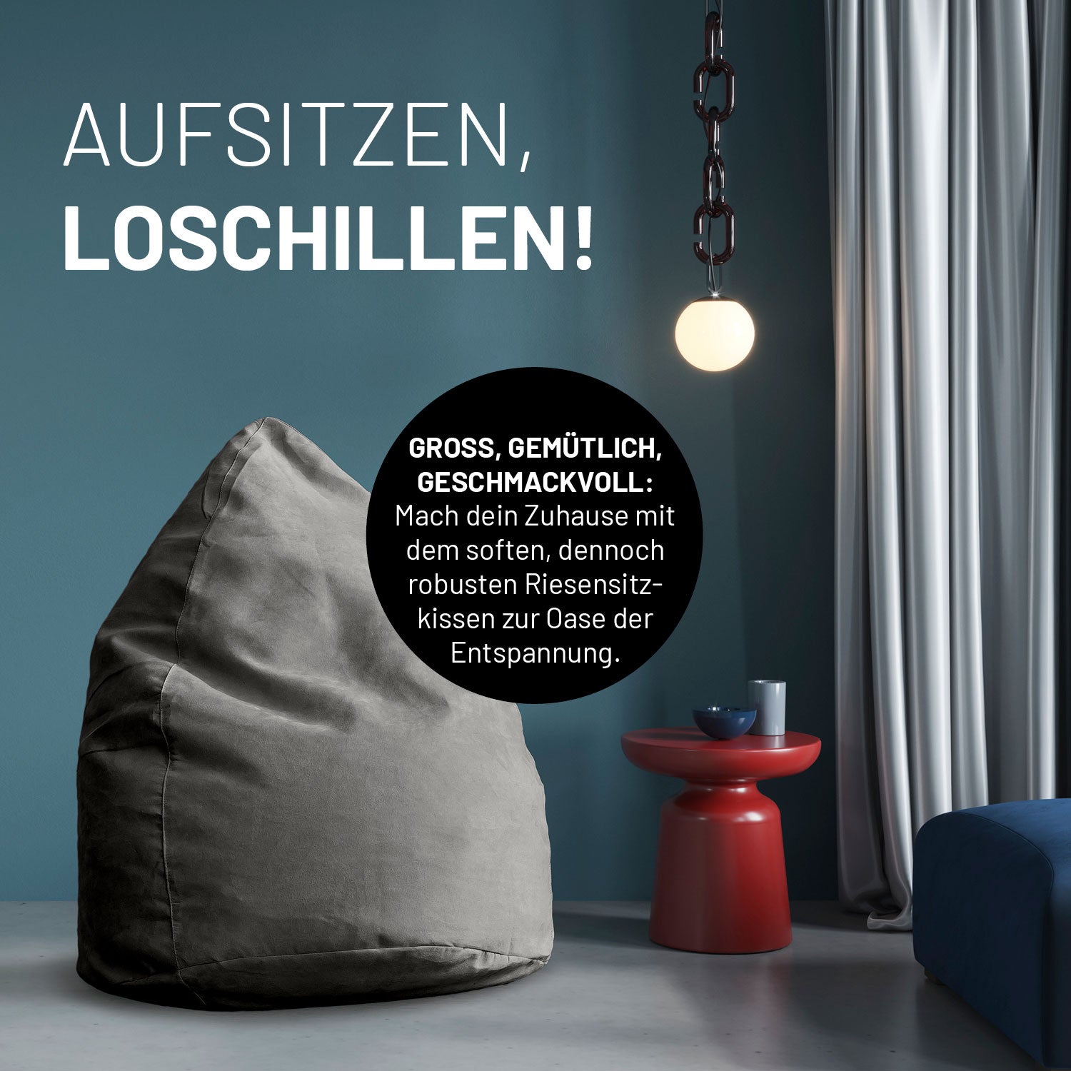 Graues Riesensitzkissen in stilvollem Raum mit blauer Wand, rotem Beistelltisch und Hängelampe - Aufsitzen & Loschillen!