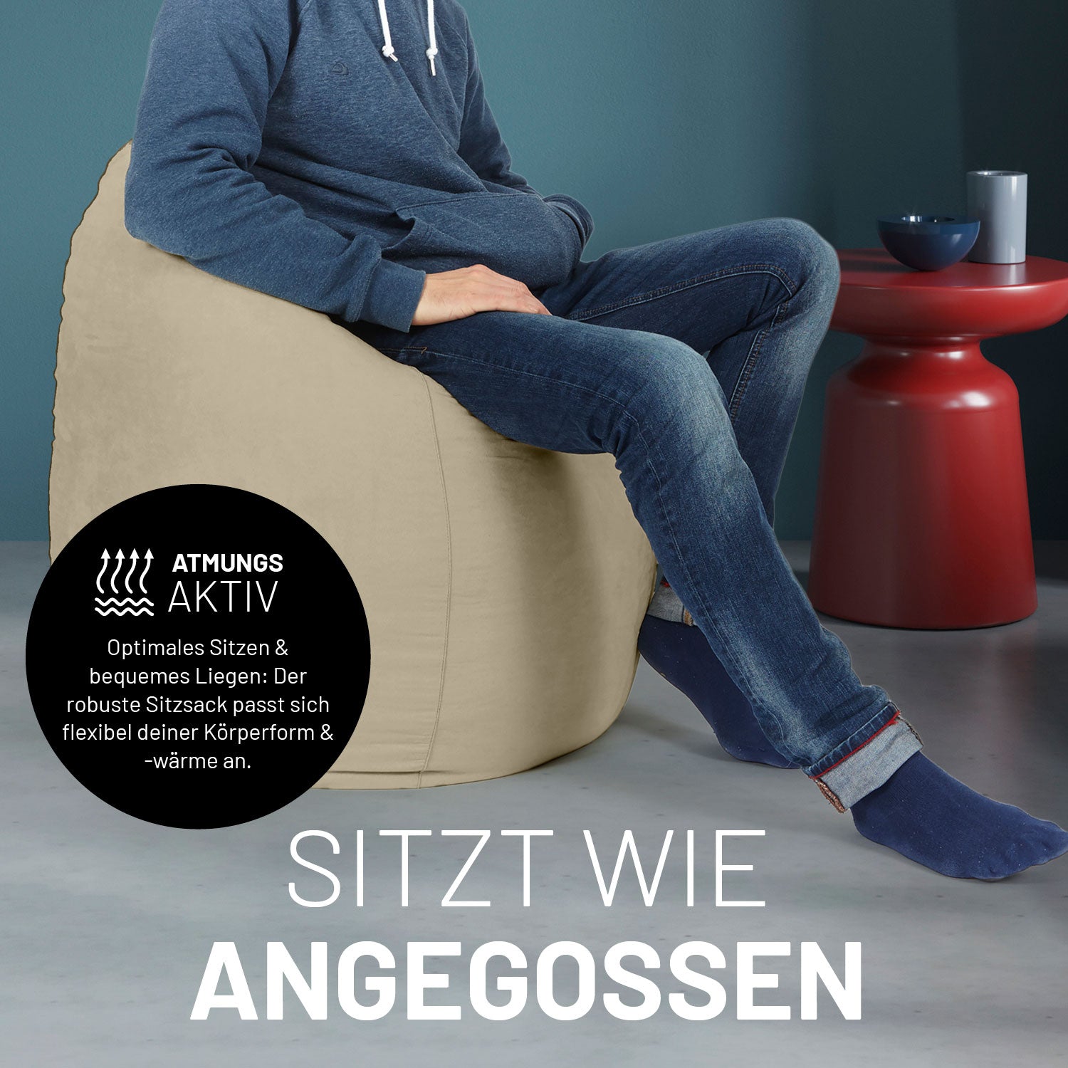 Ein Mann sitzt im beigen Sitzsack, dahinter ein roter Tisch. Icon "Atmungsaktiv - Passt sich der Körperform und -wärme an".