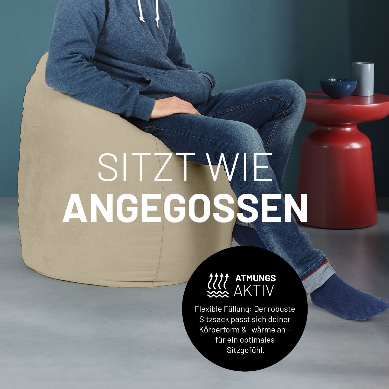 Ein Mann sitzt im beigen Sitzsack, dahinter ein roter Tisch. Icon "Atmungsaktiv - Passt sich der Körperform und -wärme an".