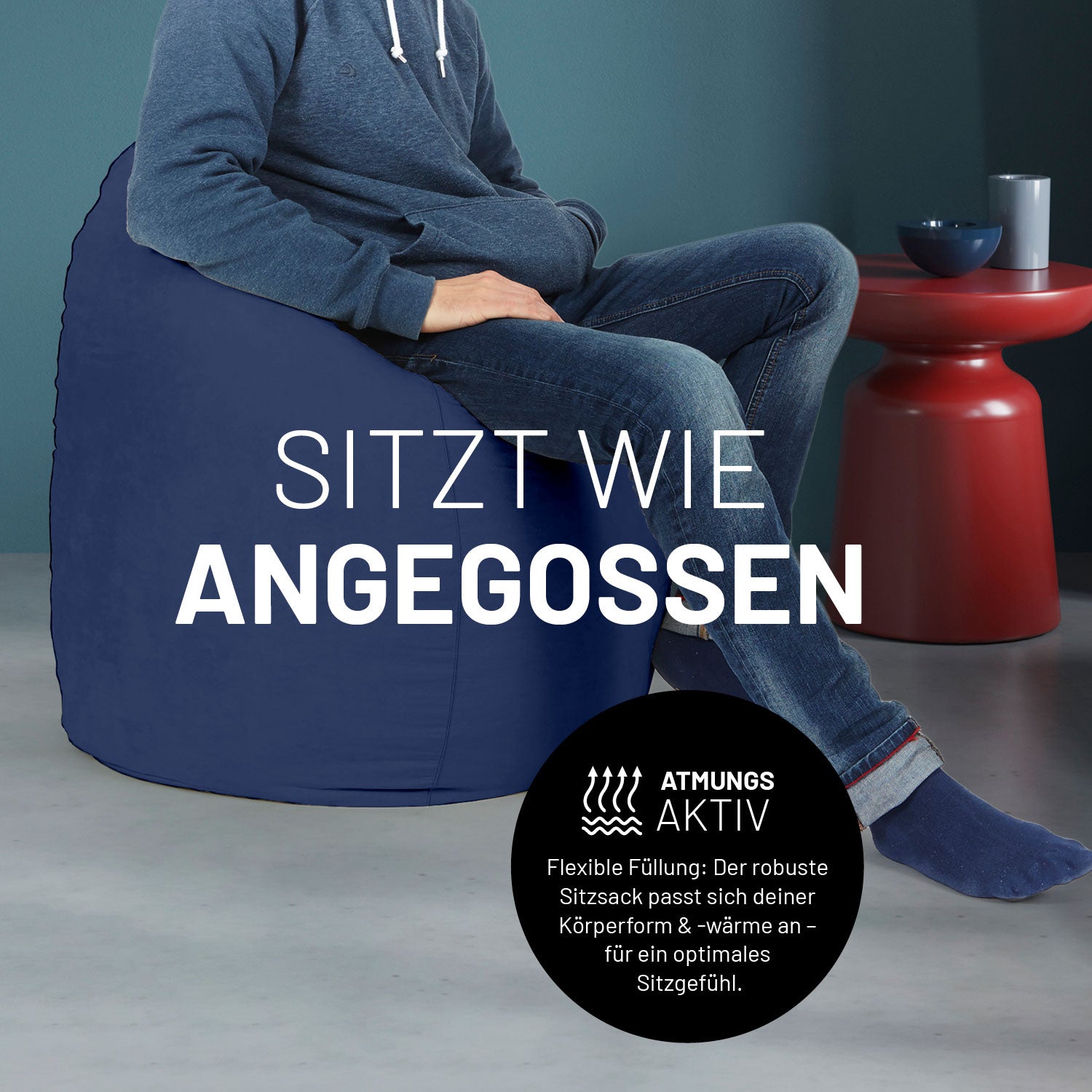 Ein Mann sitzt im blauen Sitzsack, dahinter ein roter Tisch. Icon "Atmungsaktiv - Passt sich der Körperform und -wärme an".