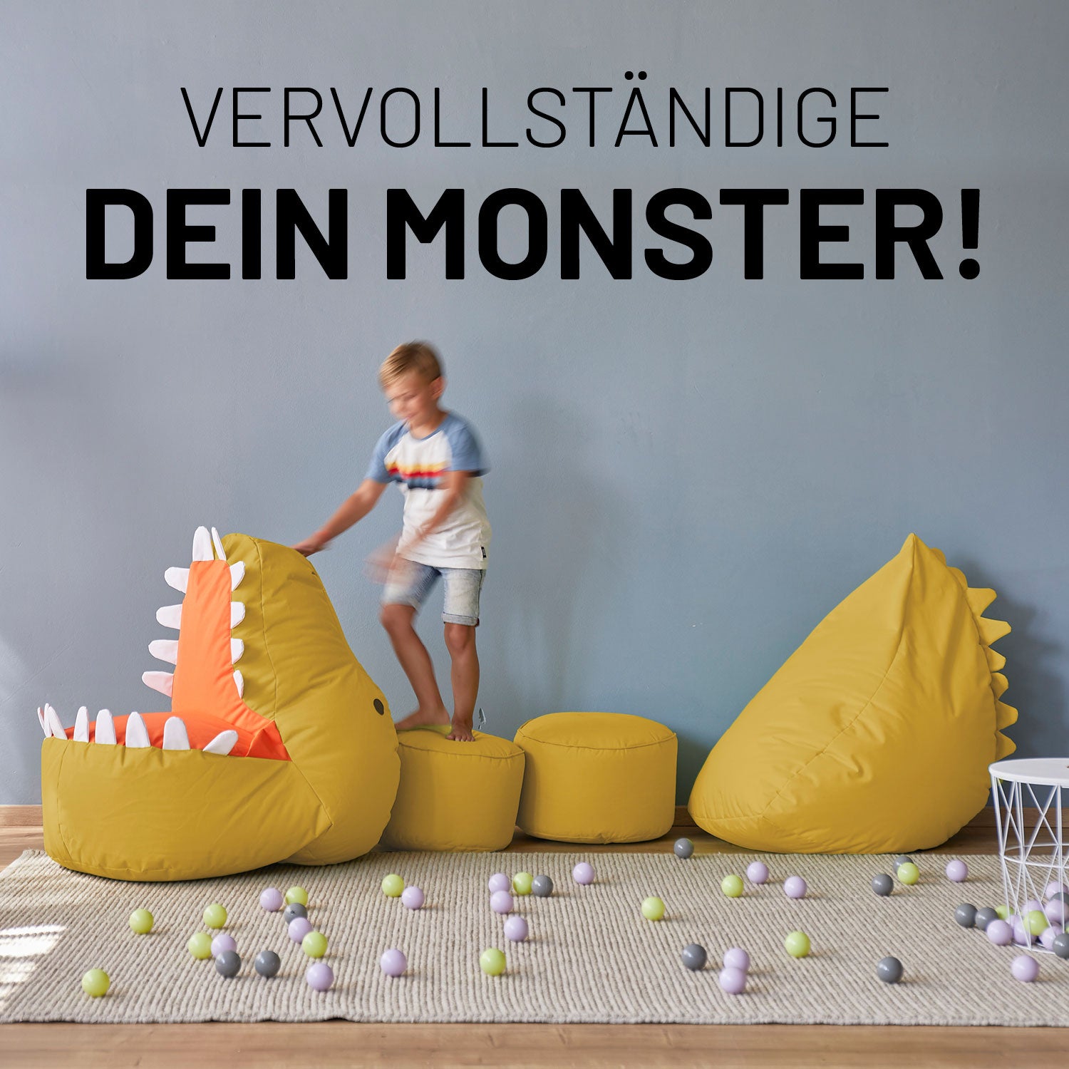 Dino, zwei farblich passende Poufs und Monster sind zu einem langen Dino zusammengelegt auf dem ein kleiner Junge spielt.