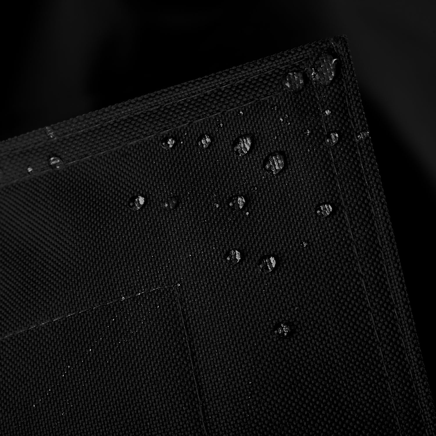 Sitzsackhülle des XXL Sitzsackes von LUMALAND in Schwarz im Detail mit Wassertropfen - Wasserabweisende Hülle.