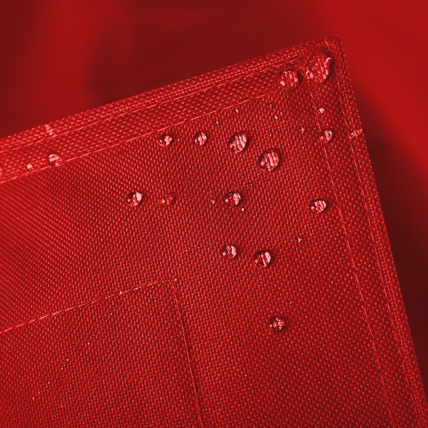 Sitzsackhülle des XXL Sitzsackes von LUMALAND in Rot im Detail mit Wassertropfen - Wasserabweisende Hülle.