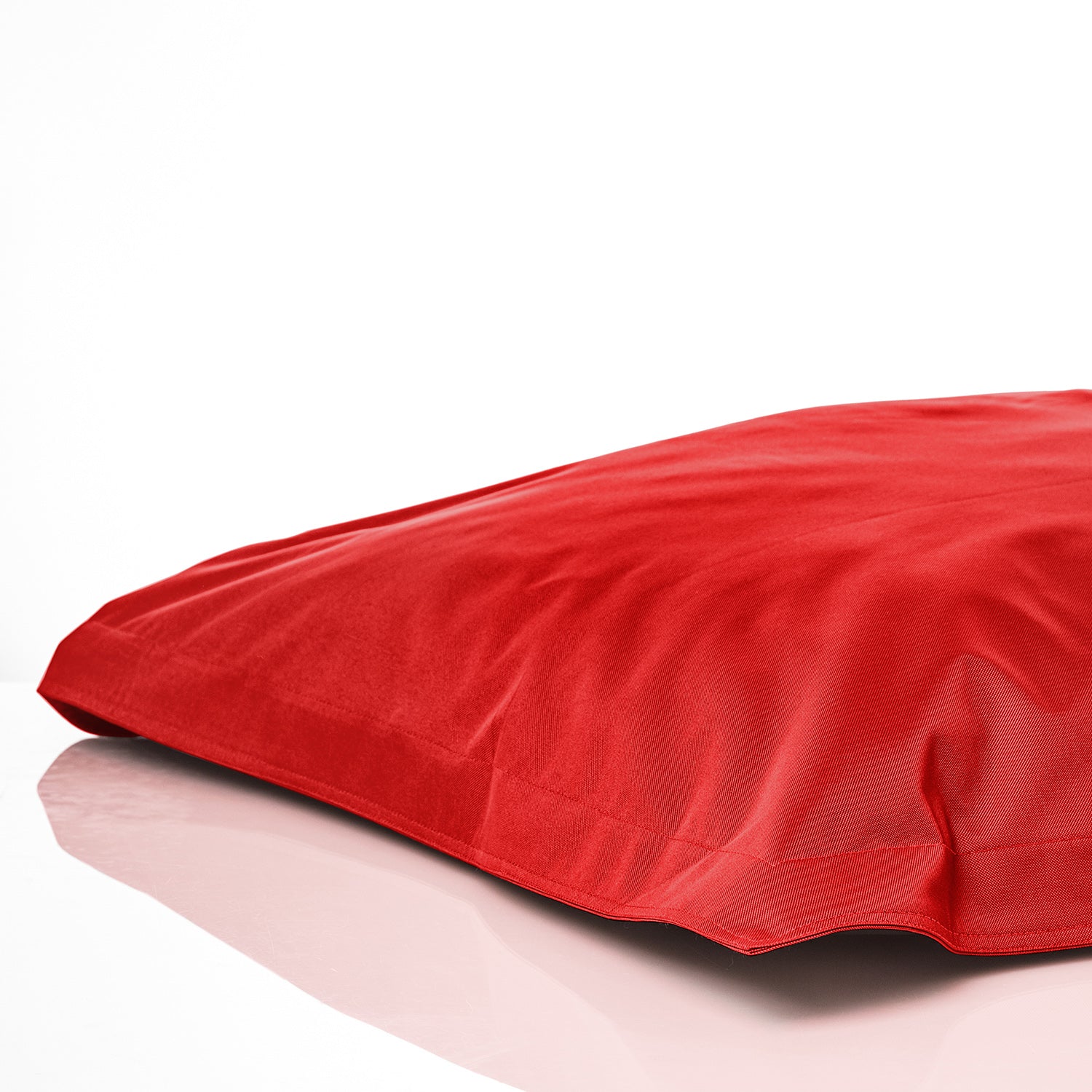 Sitzsackhülle in Rot auf dem Boden liegend vor weißen Hintergrund.