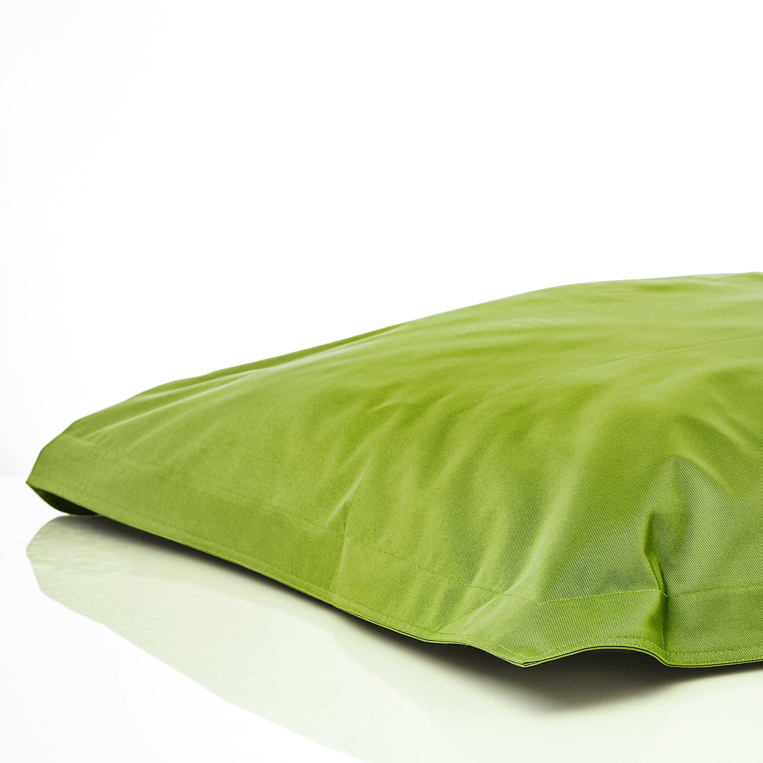 Sitzsackhülle in Grün auf dem Boden liegend vor weißen Hintergrund.