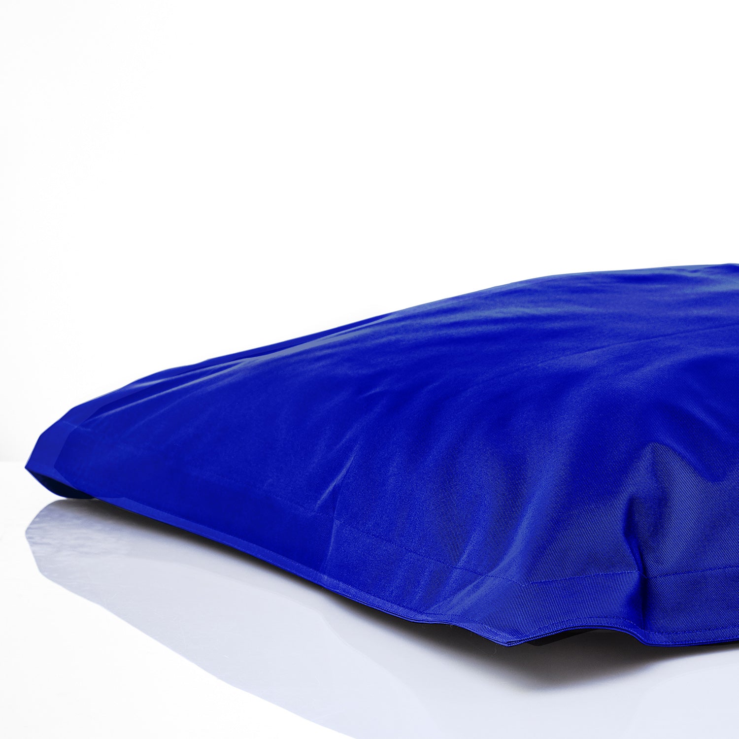 Sitzsackhülle in Royalblau auf dem Boden liegend vor weißen Hintergrund.