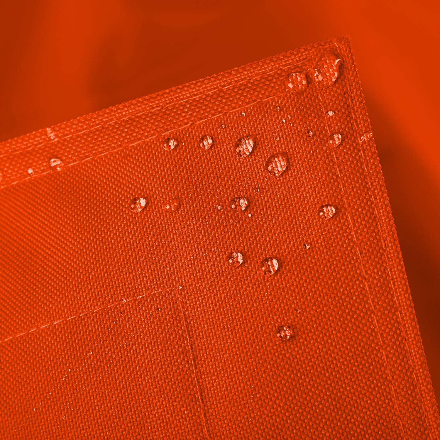 Sitzsackhülle des XXL Sitzsackes von LUMALAND in Orange im Detail mit Wassertropfen - Wasserabweisende Hülle.