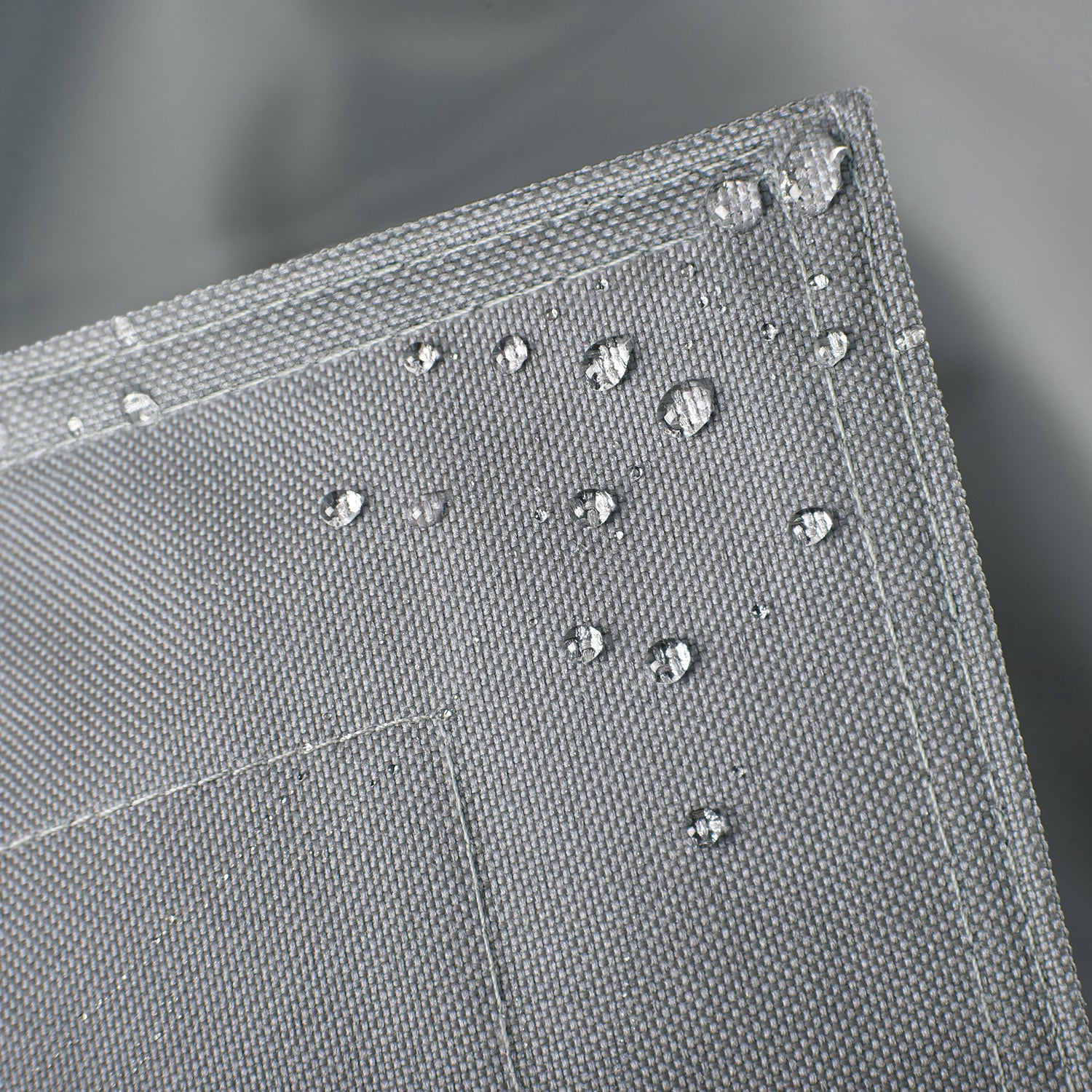 Sitzsackhülle des XXL Sitzsackes von LUMALAND in Grau im Detail mit Wassertropfen - Wasserabweisende Hülle.