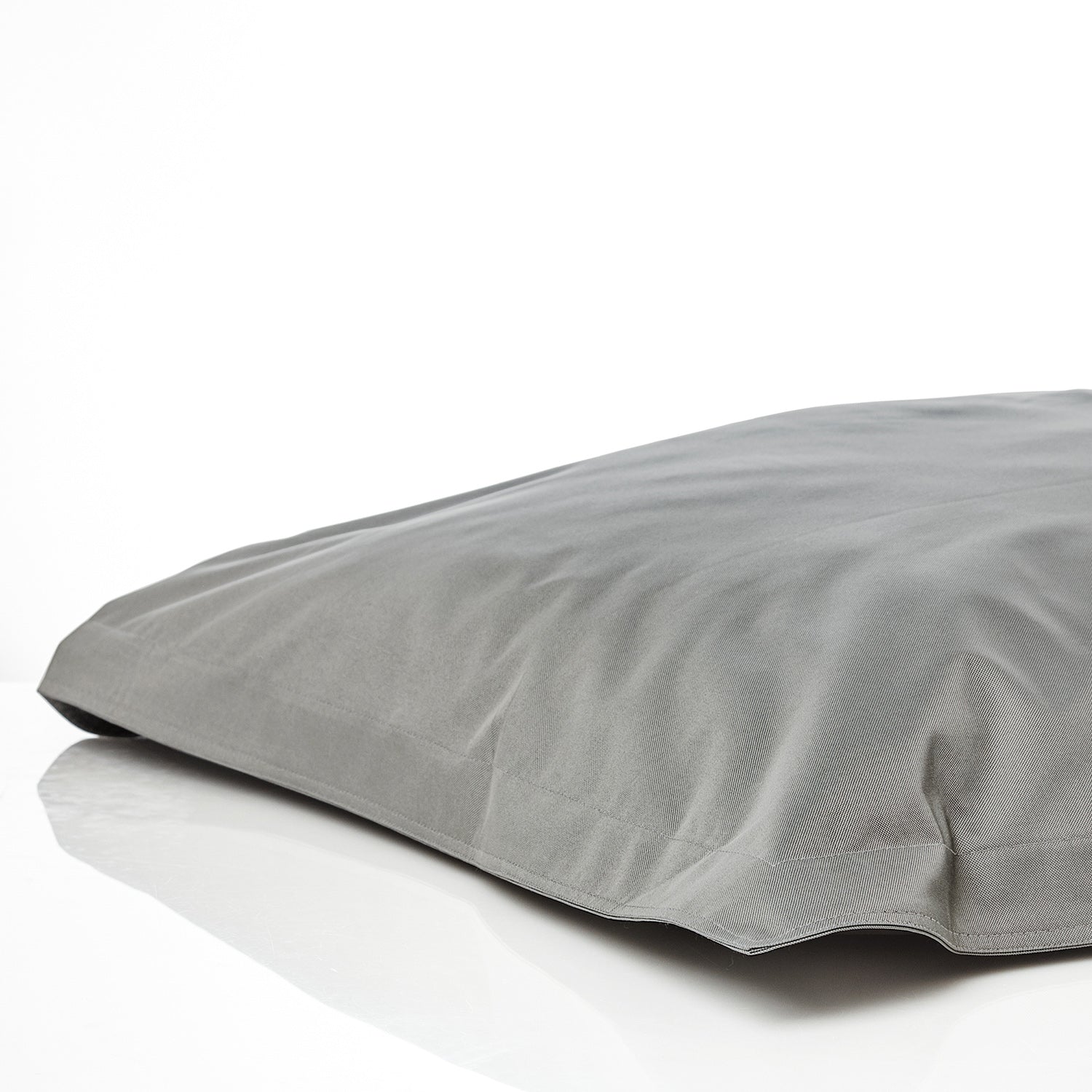 Sitzsackhülle in Grau auf dem Boden liegend vor weißen Hintergrund.