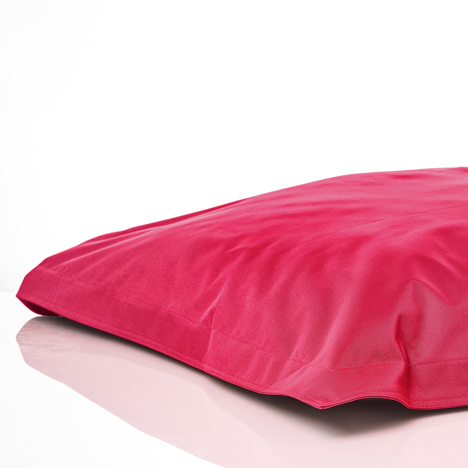 Sitzsackhülle in Pink auf dem Boden liegend vor weißen Hintergrund.