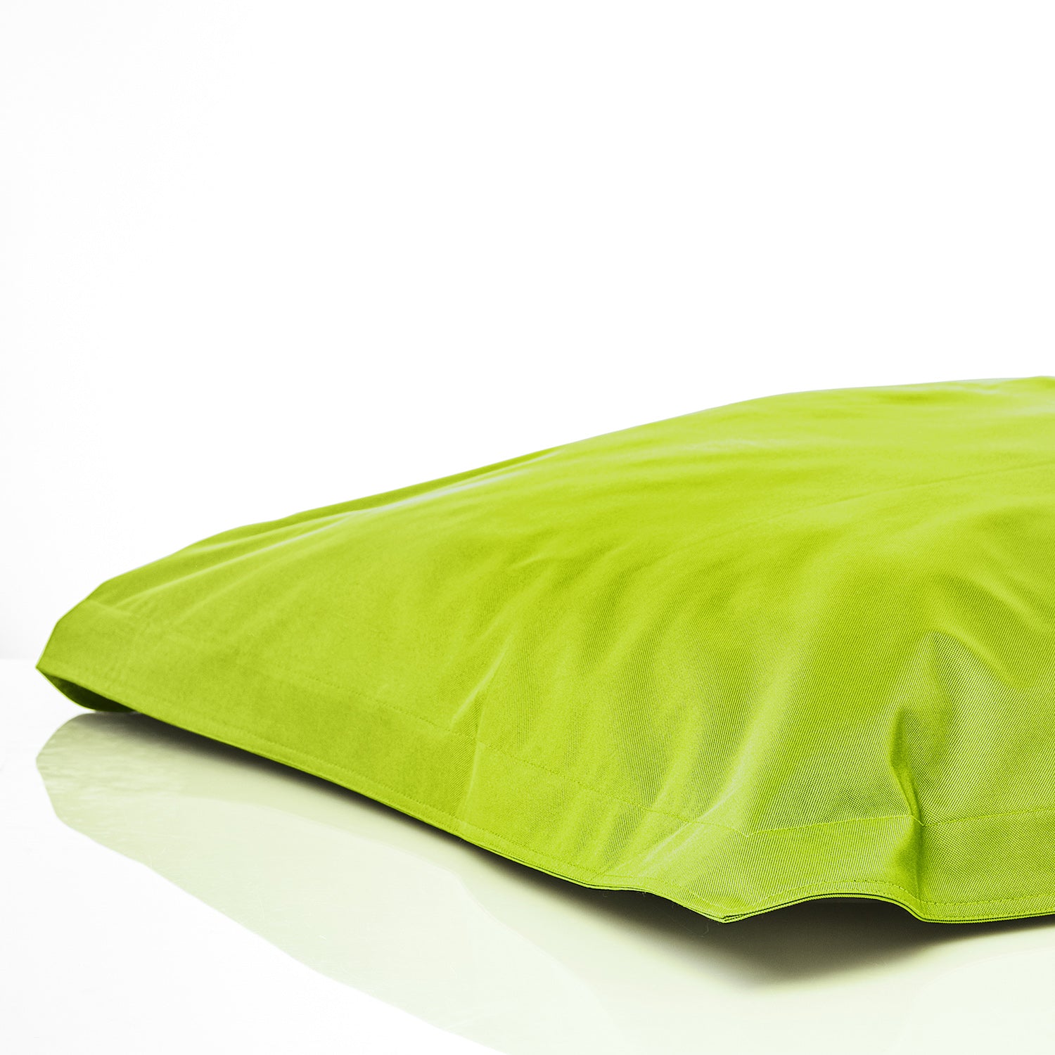 Sitzsackhülle in Apfelgrün auf dem Boden liegend vor weißen Hintergrund.