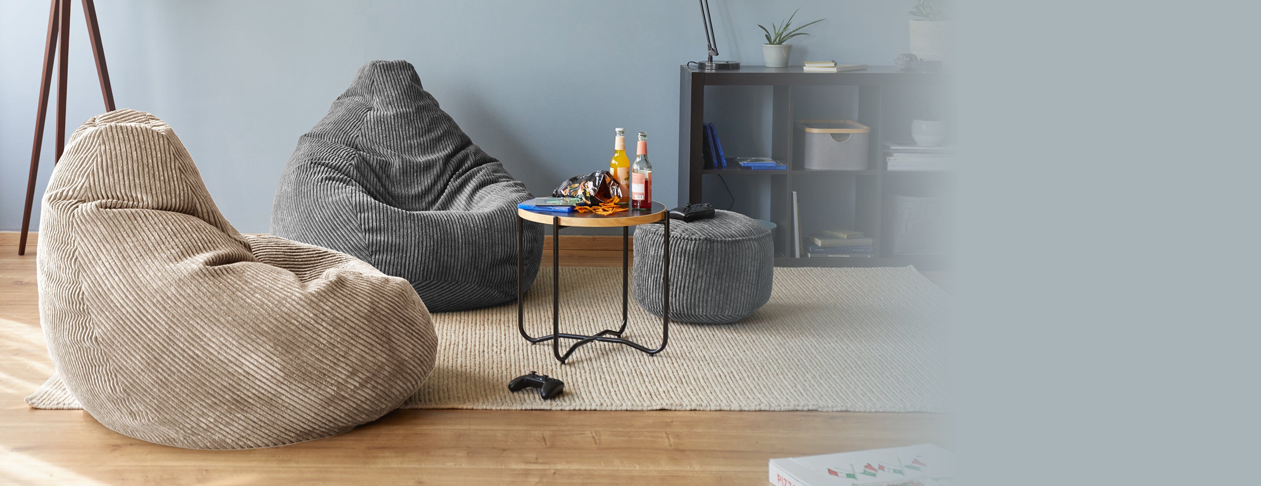 Beiger und grauer CORD Sitzsack, sowie der graue CORD-Pouf in einem Wohnzimmer.