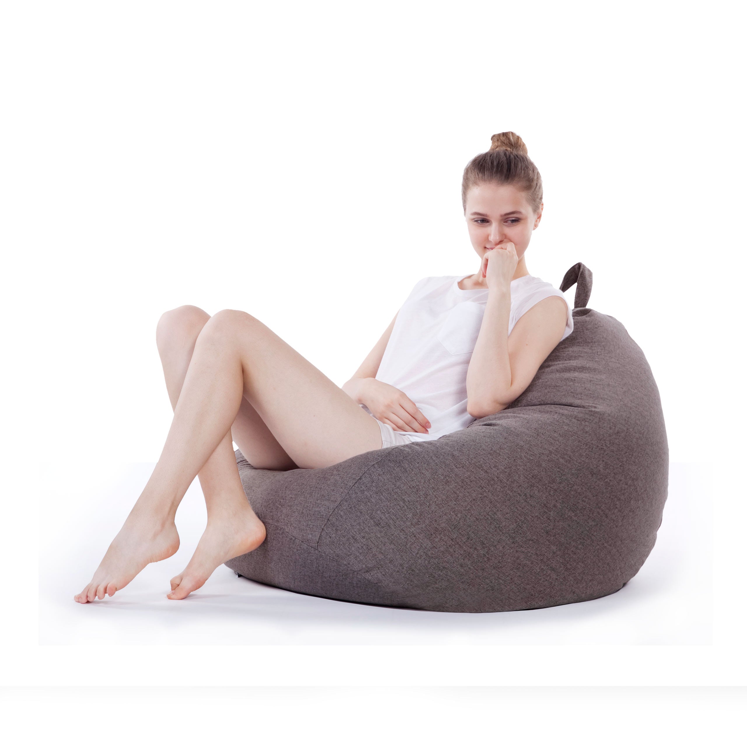 Eine Frau sitzt gemütlich im Comfort Line Sitzsack in Dunkelgrau und schaut zu Boden.
