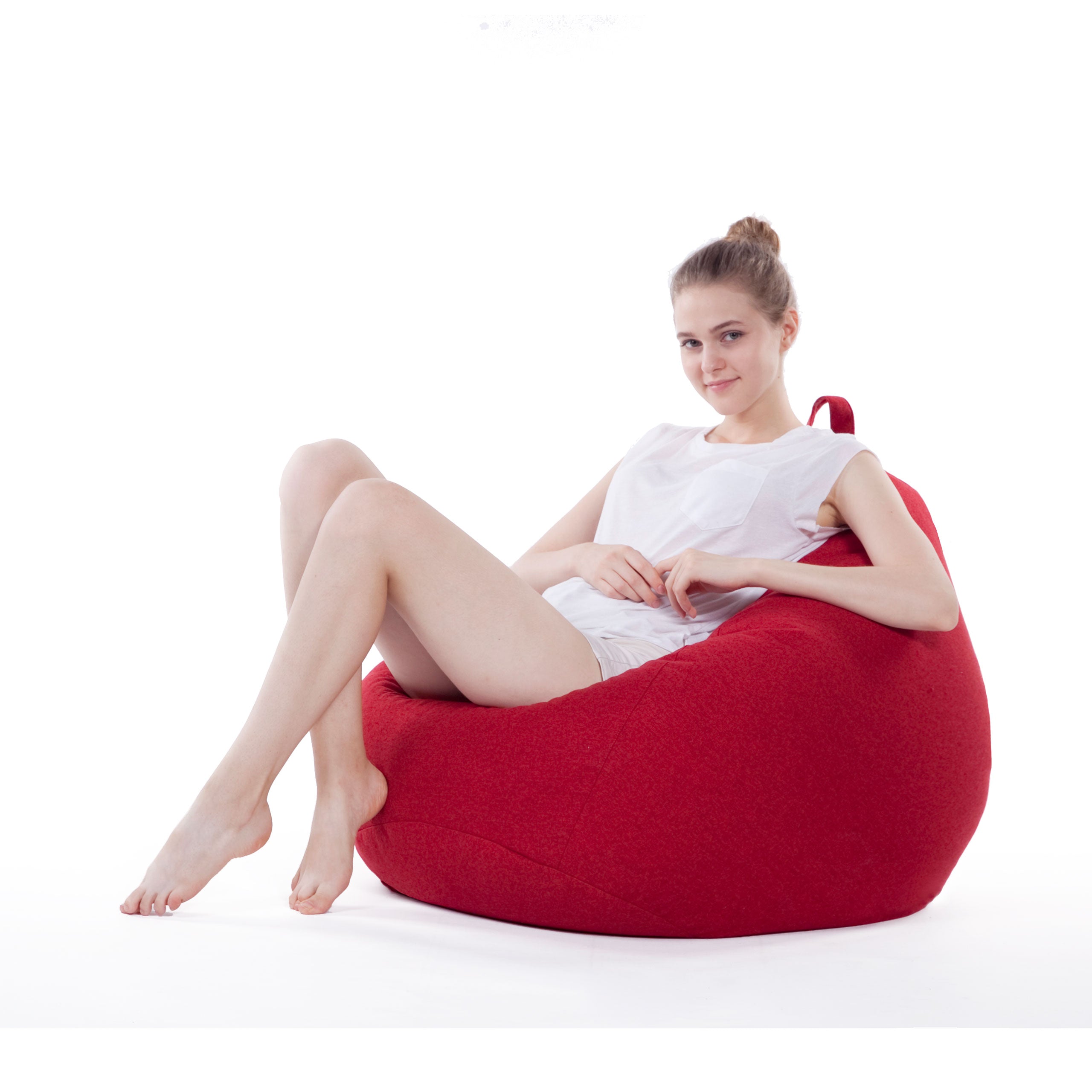 Eine Frau sitzt gemütlich im Comfort Line Sitzsack in Rot und schaut zu in die Kamera.