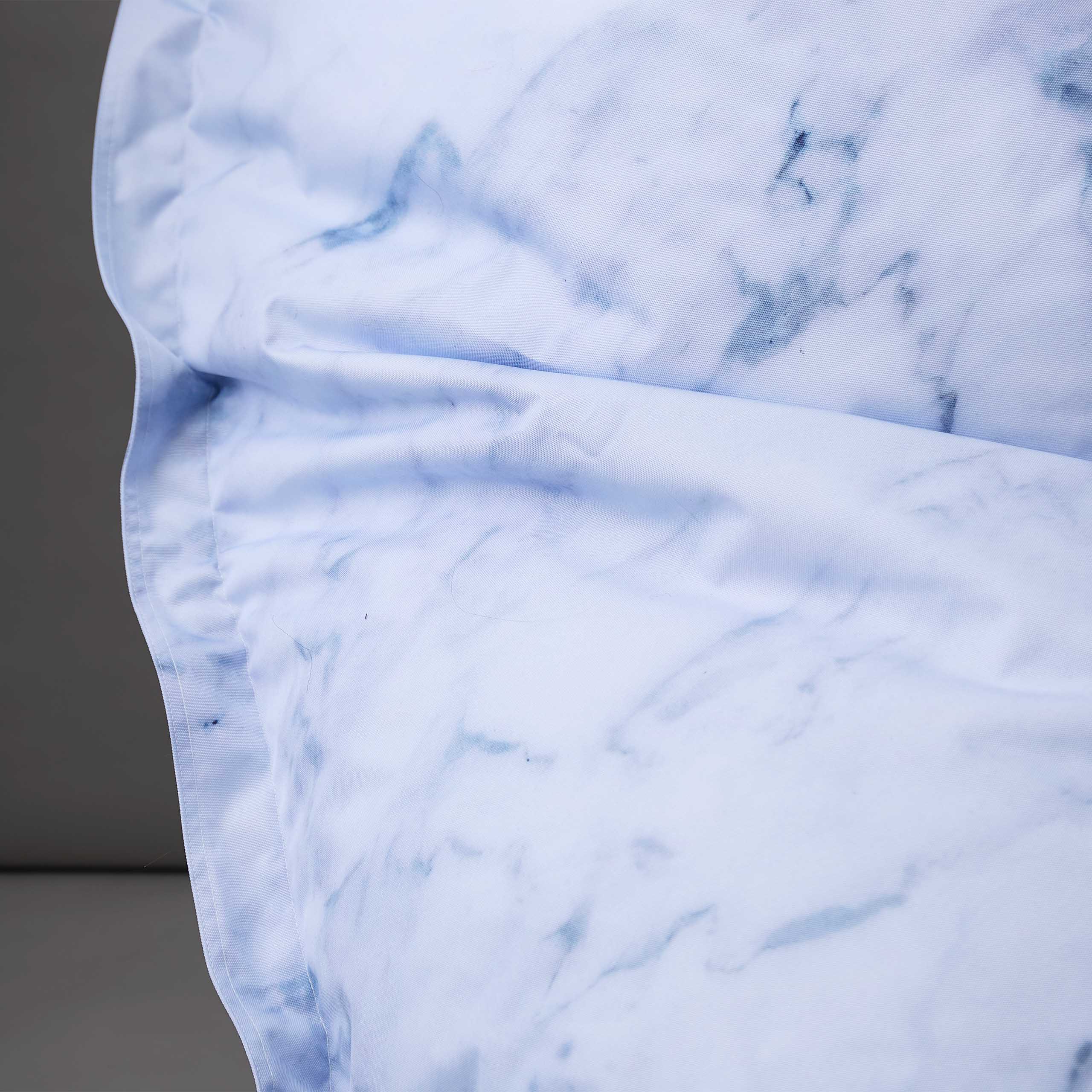 Muster und Material des LUMALAND Printed Edition Sitzsackes in Marmor-Optik vor grauer Wand.