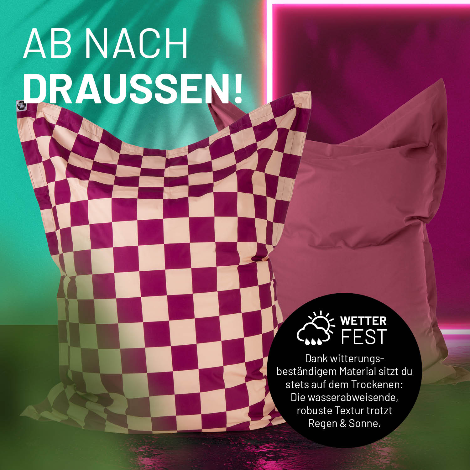 Der XXL Sitzsack mit karierter Vorder- und unifarbener weinroter Rückseite in einer Outdoorszene mit Hinweis zur Wetterfestigkeit. 