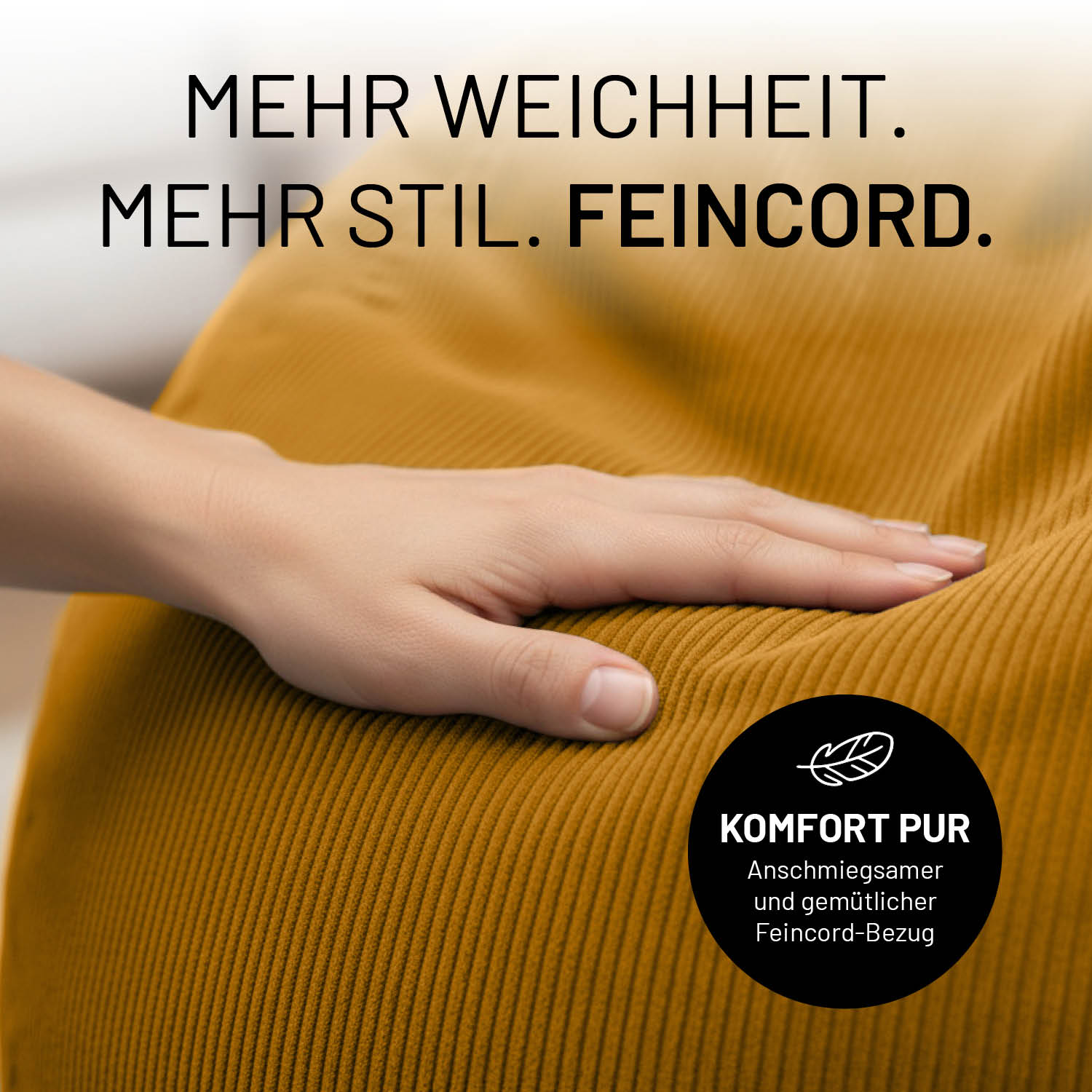 Eine Hand liegt auf dem senfgelben Feincord-Bezug eines Sitzsacks. Hinweis auf weiches Material, Komfort und anschmiegsame Oberfläche.