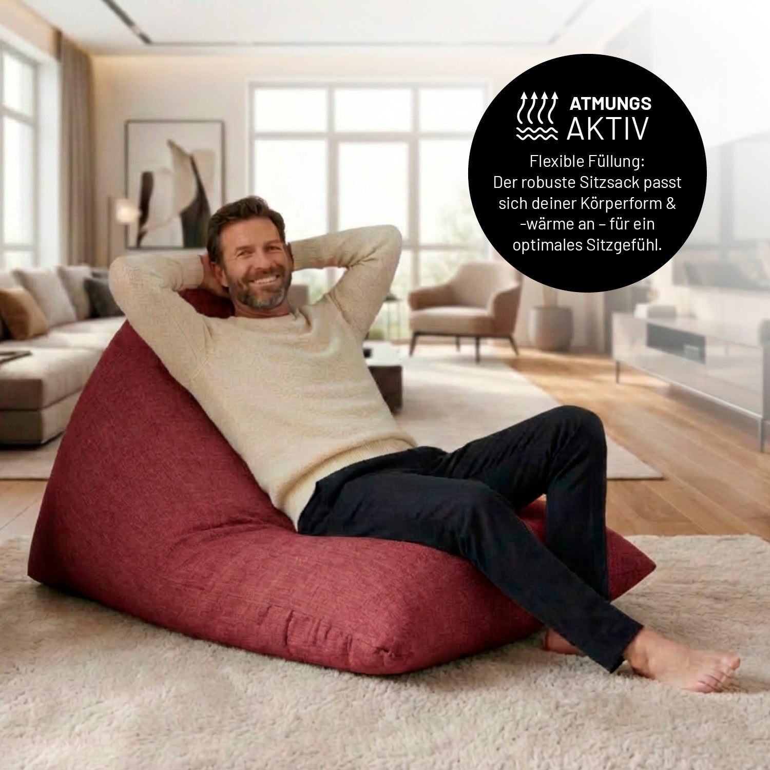 Ein Mann lehnt entspannt auf dem Sitzsack in Rot in einem Wohnzimmer. Icon zu „atmungsaktiv“ und "flexible Füllung, die sich der Körperform und Wärme anpasst".