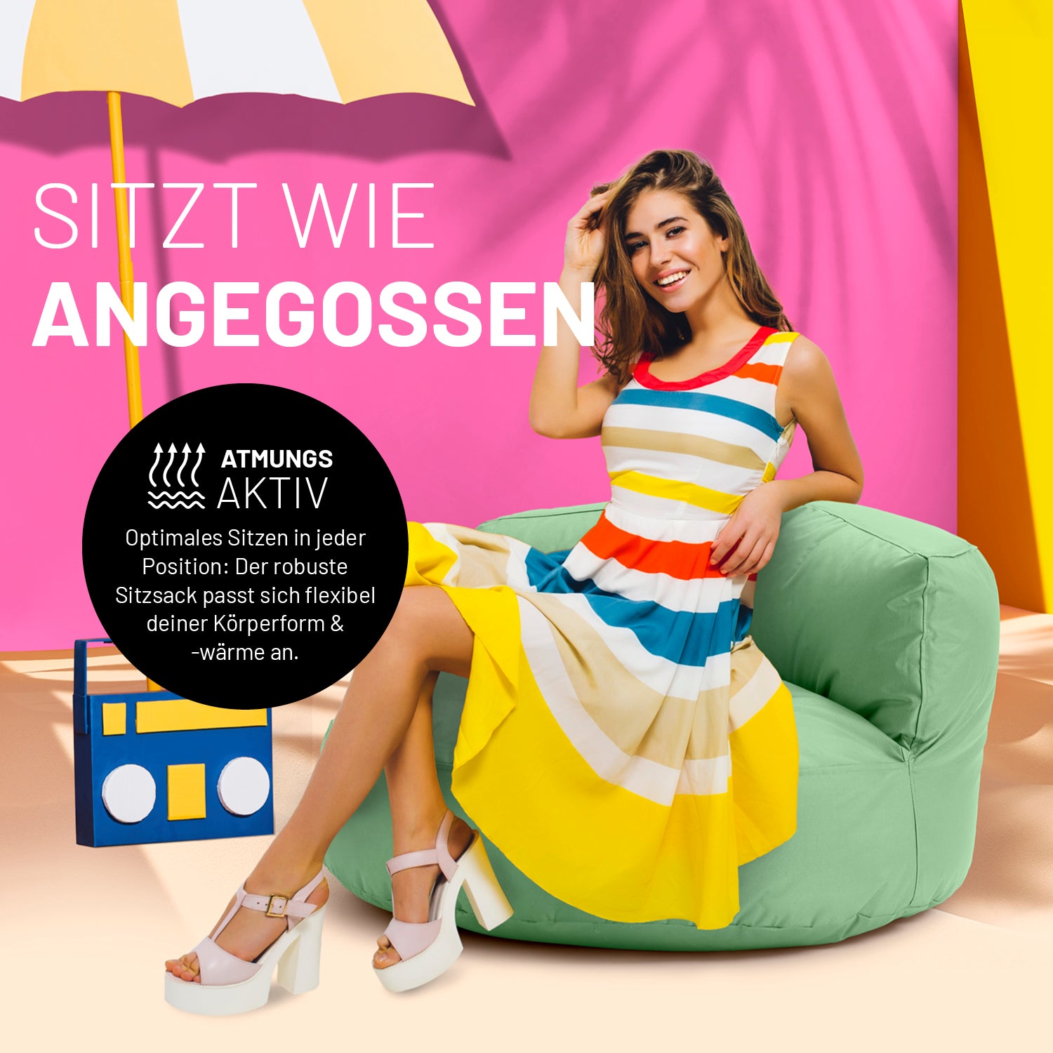 Eine Frau in buntem Kleid sitzt auf dem pastellgrünen Sitzsack-Sofa. Icon "Atmungsaktiv" und "Passt sich Körperform und -wärme an".