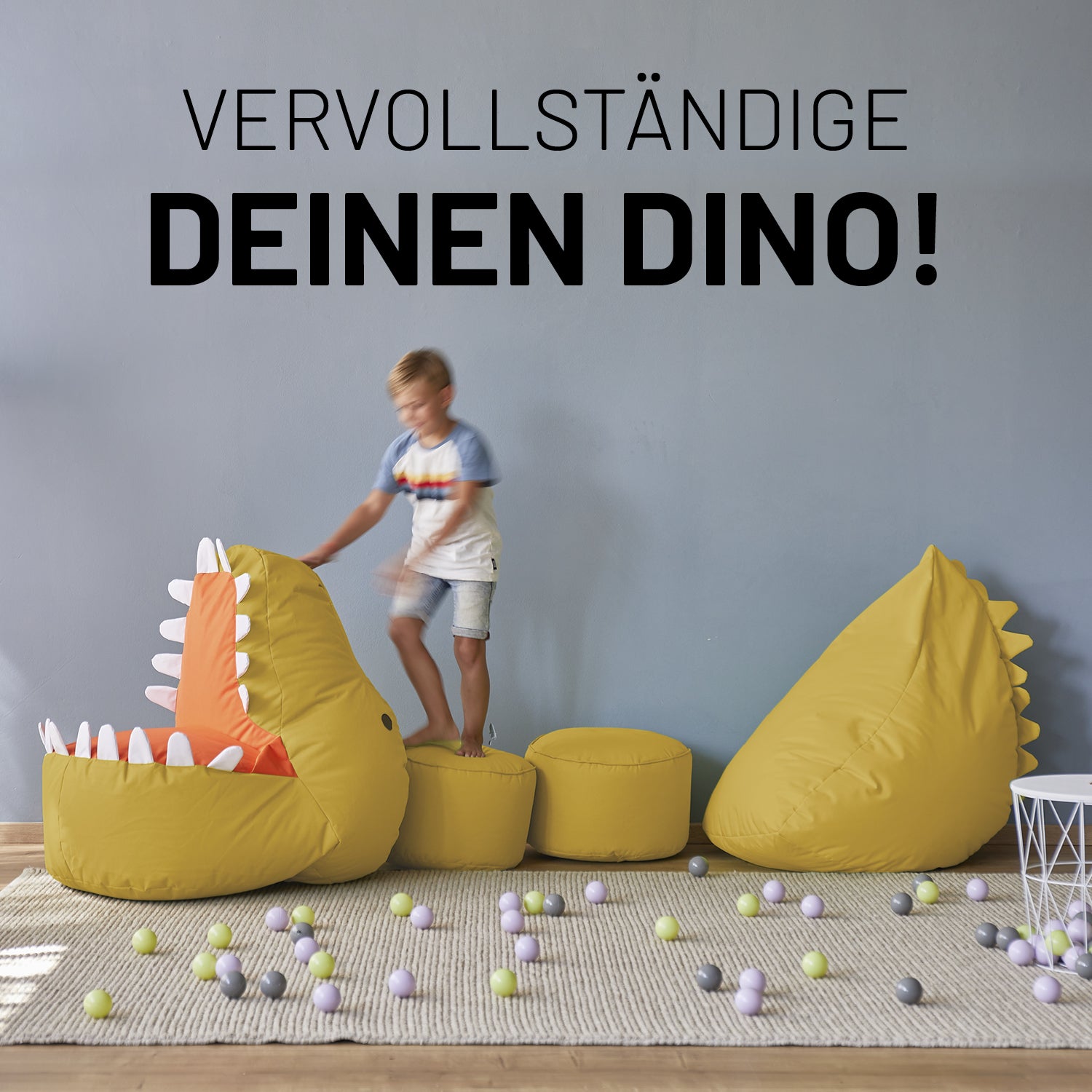 Dino, zwei farblich passende Poufs und Monster sind zu einem langen Dino zusammengelegt auf dem ein kleiner Junge spielt.