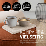 Multihocker in Terracotta mit darauf abgelegten Buch und Tasse für verschiedene Anwendungsbereiche: Hocker, Tisch und Fußbablage.