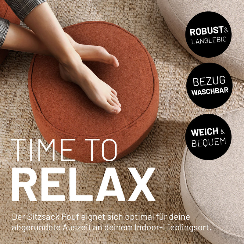 Überkreuzte Beine abgelegt auf dem Hocker/Pouf aus der LUMALAND Teddy-Reihe in einer Indoor-Szene.