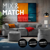 Moderner Wohnraum mit den grauen Elementen des Modularen System verbunden zu einem Sitzsofa und freistehenden Cord-Sessel und Cord-Hocker.
