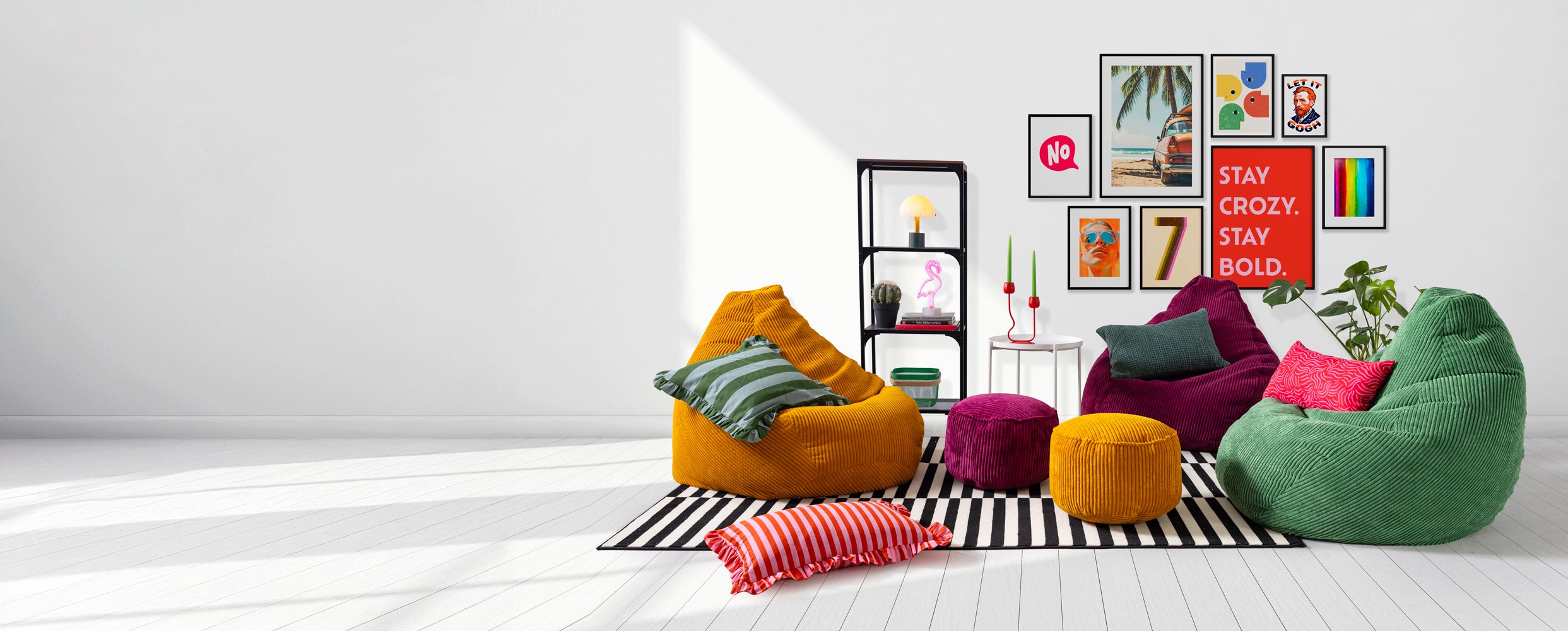 Bunte Cord-Sitzsäcke in Senfgelb, Dunkelgrün und Weinrot mit passenden Poufs und Kissen in einem modernen, farbenfrohen Wohnzimmer mit Wandgalerie.