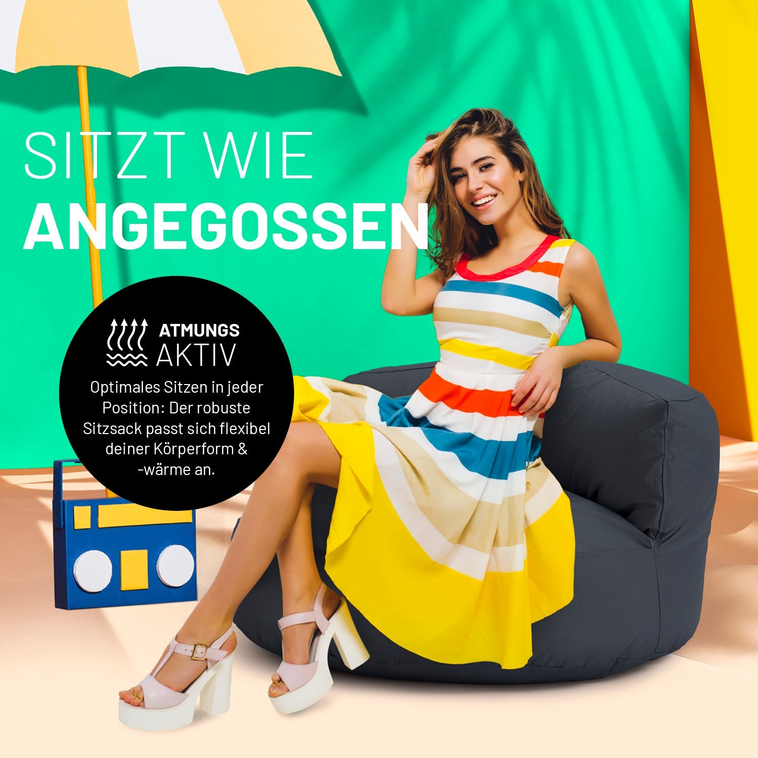 Eine Frau in buntem Kleid sitzt auf dem grauen Sitzsack-Sofa. Icon "Atmungsaktiv" und "Passt sich Körperform und -wärme an".